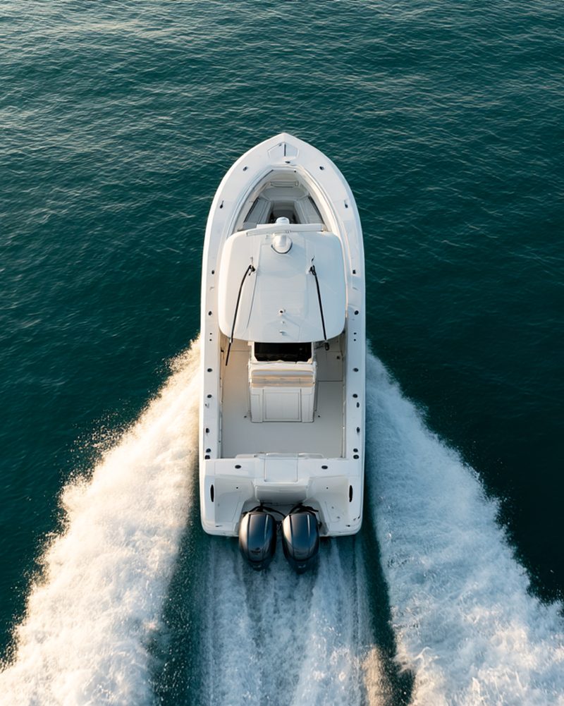 Aerial view of a center console powerboat running straight ahead with twin outboards