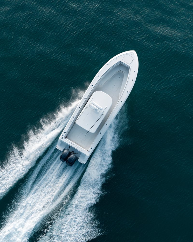 Aerial view of a powerboat on plane leaving a white wake